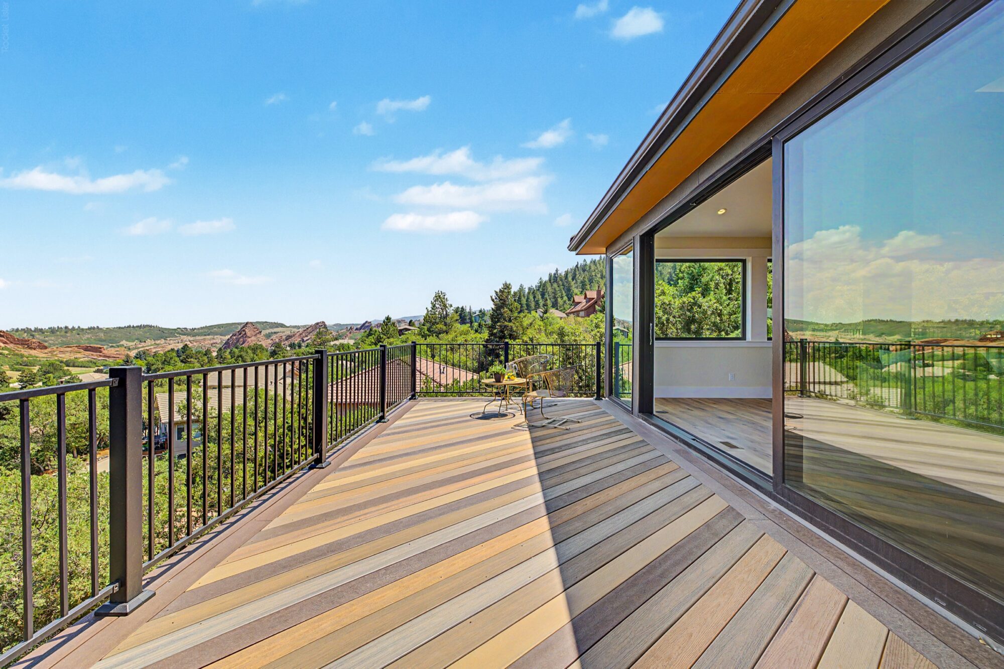 Jet Black Win-Dor 3750 Series sliding patio door with one panel open, exterior view from the deck.