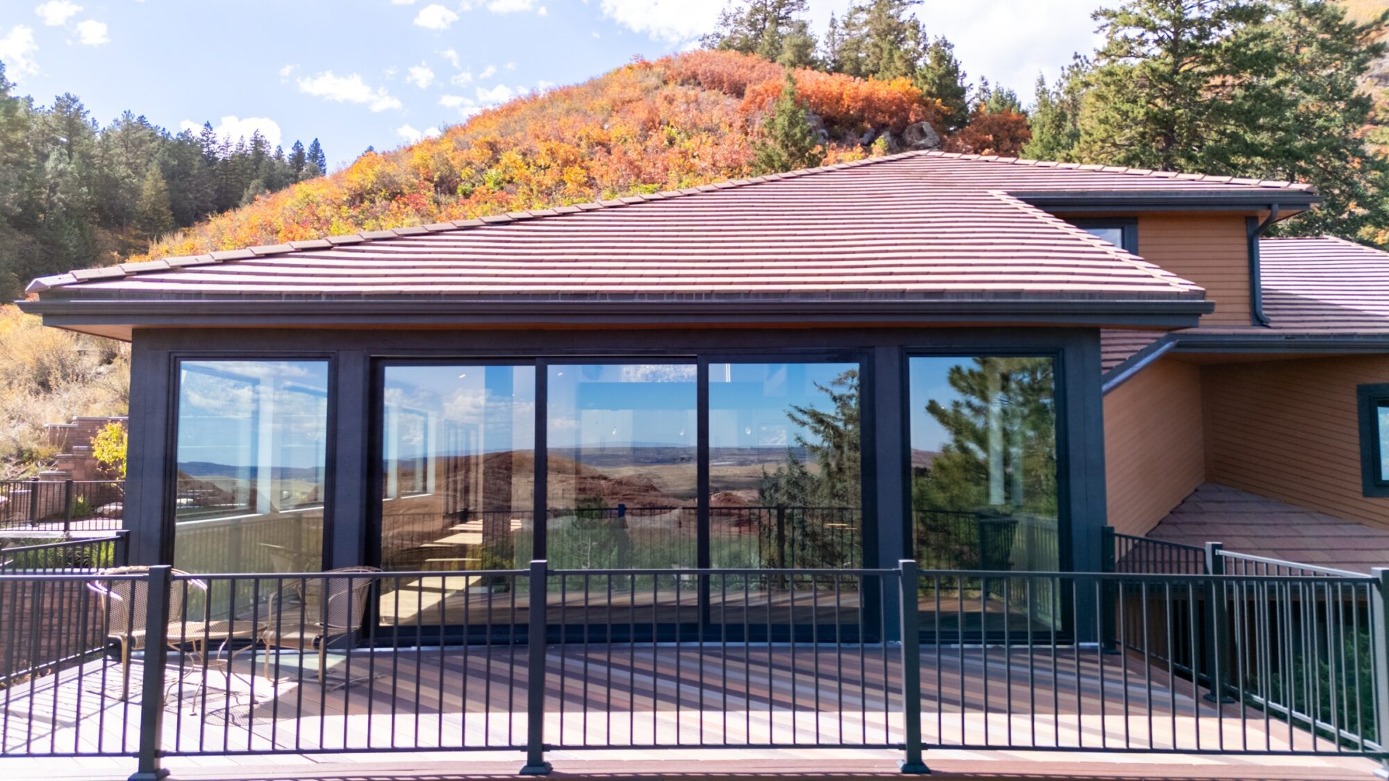 Jet Black Win-Dor 3750 Series sliding patio door between tall 1750 Series picture windows, exterior deck view.