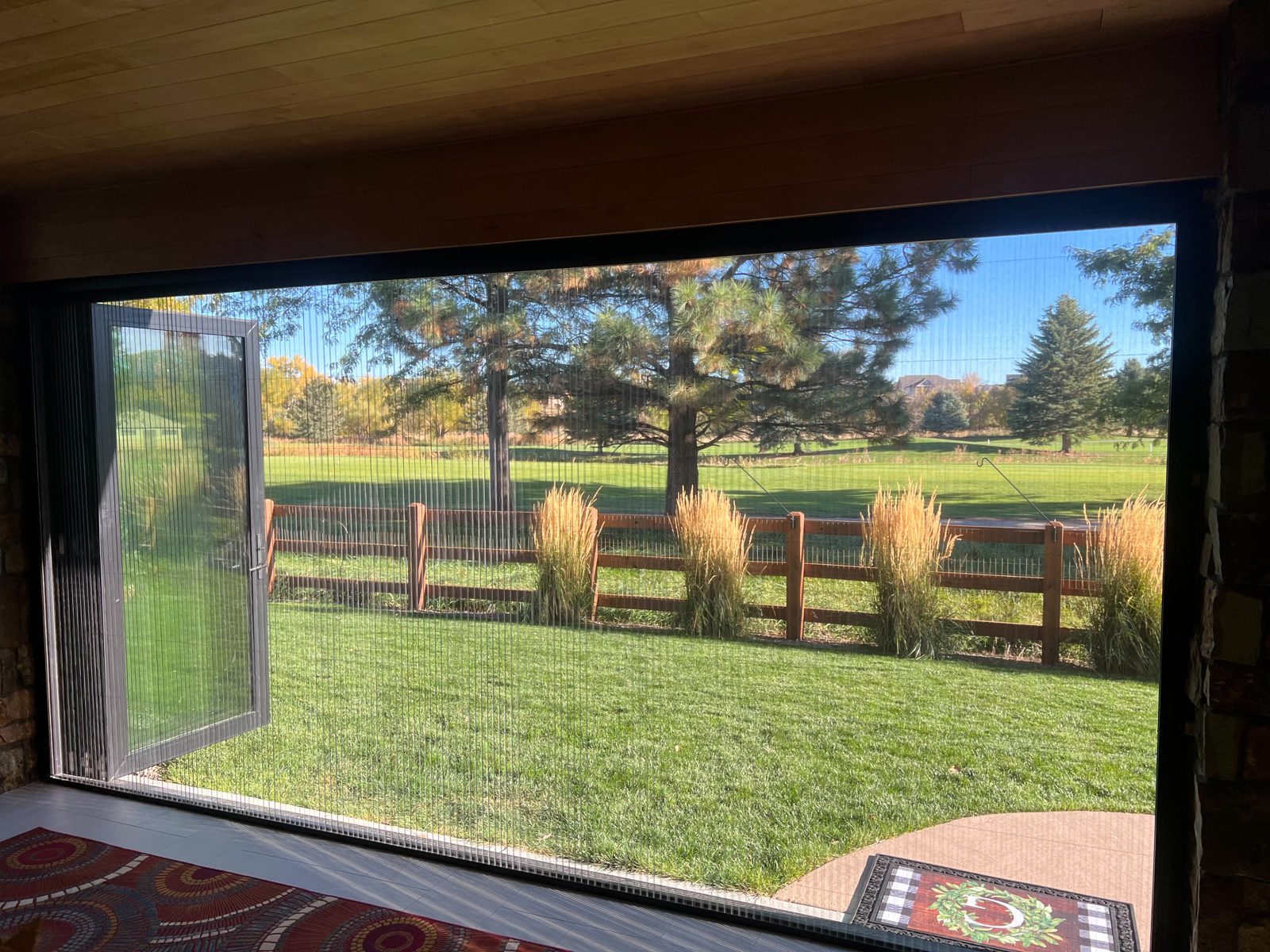 Black Win-Dor folding patio door with a Genius retractable pleated screen, seen from inside