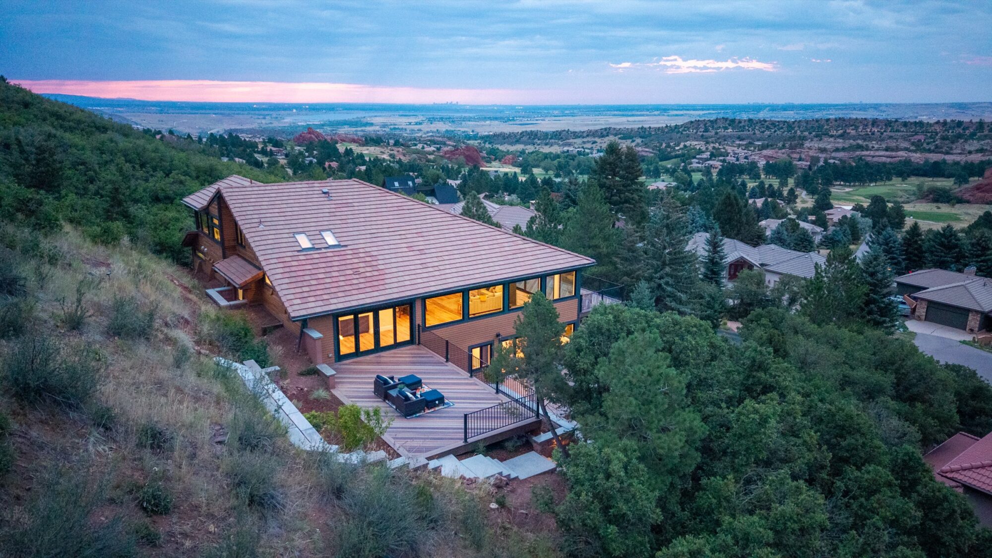 Wide aerial dusk view of the rear deck with Jet Black Win-Dor 1750 Series windows lit from inside.