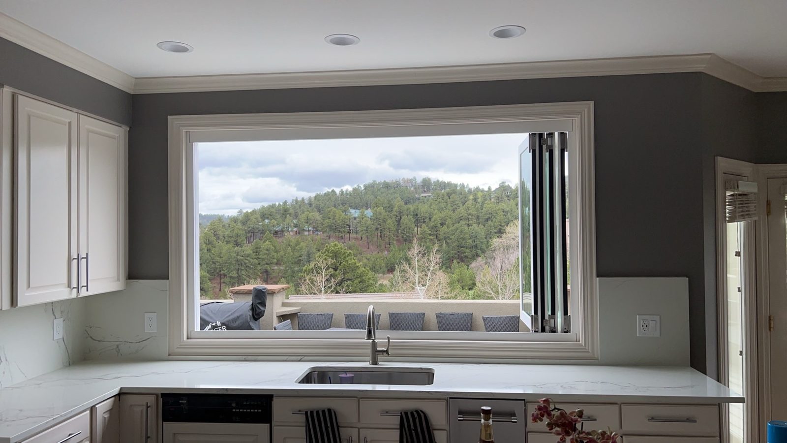 White Win-Dor bifold window fully folded open over a kitchen sink