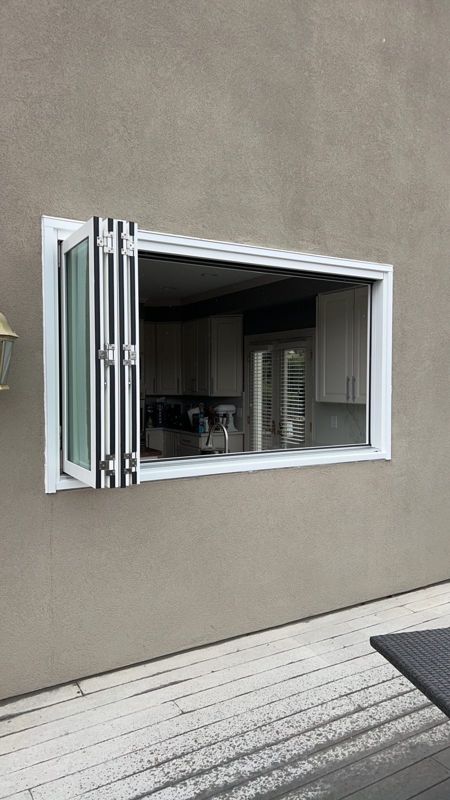 White Win-Dor bifold window folded open as a pass-through, seen from outside