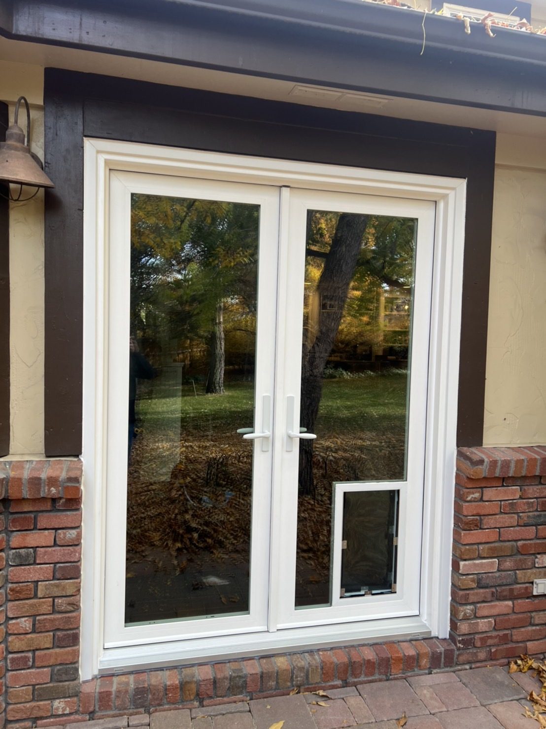 White Win-Dor in-swing French patio door with a Hale pet door in the glass, seen from outside